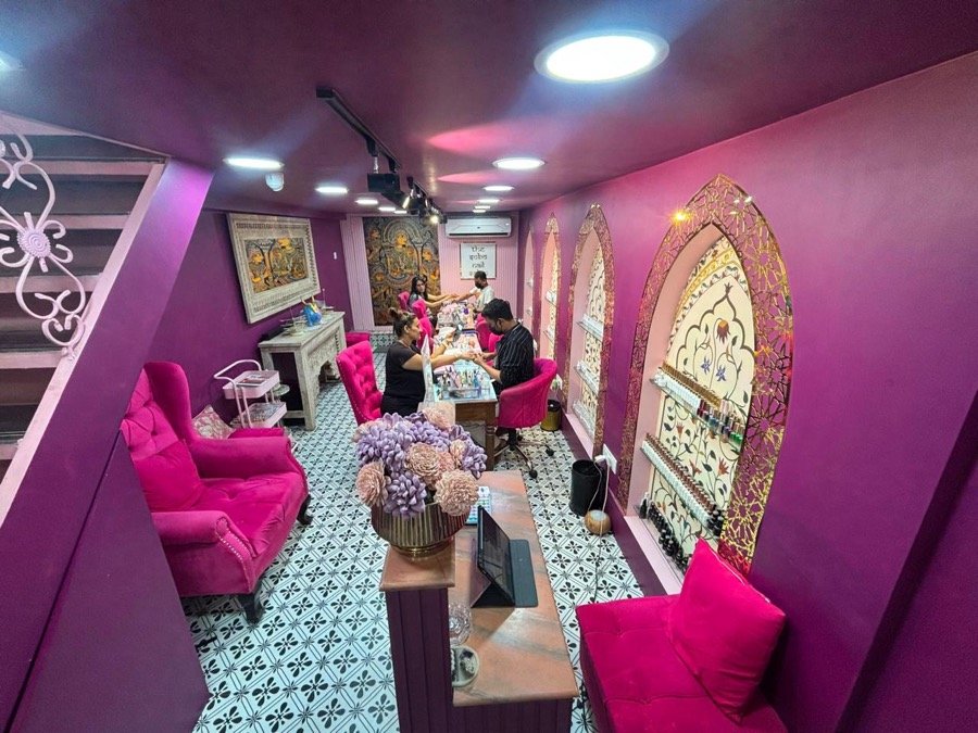 The SoBo Nail Salon Seawoods in session — pink chairs and gold arches